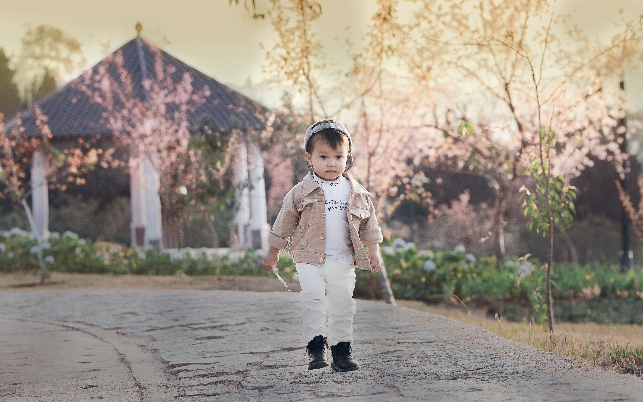 Милый мальчик гуляет по дороге у дома