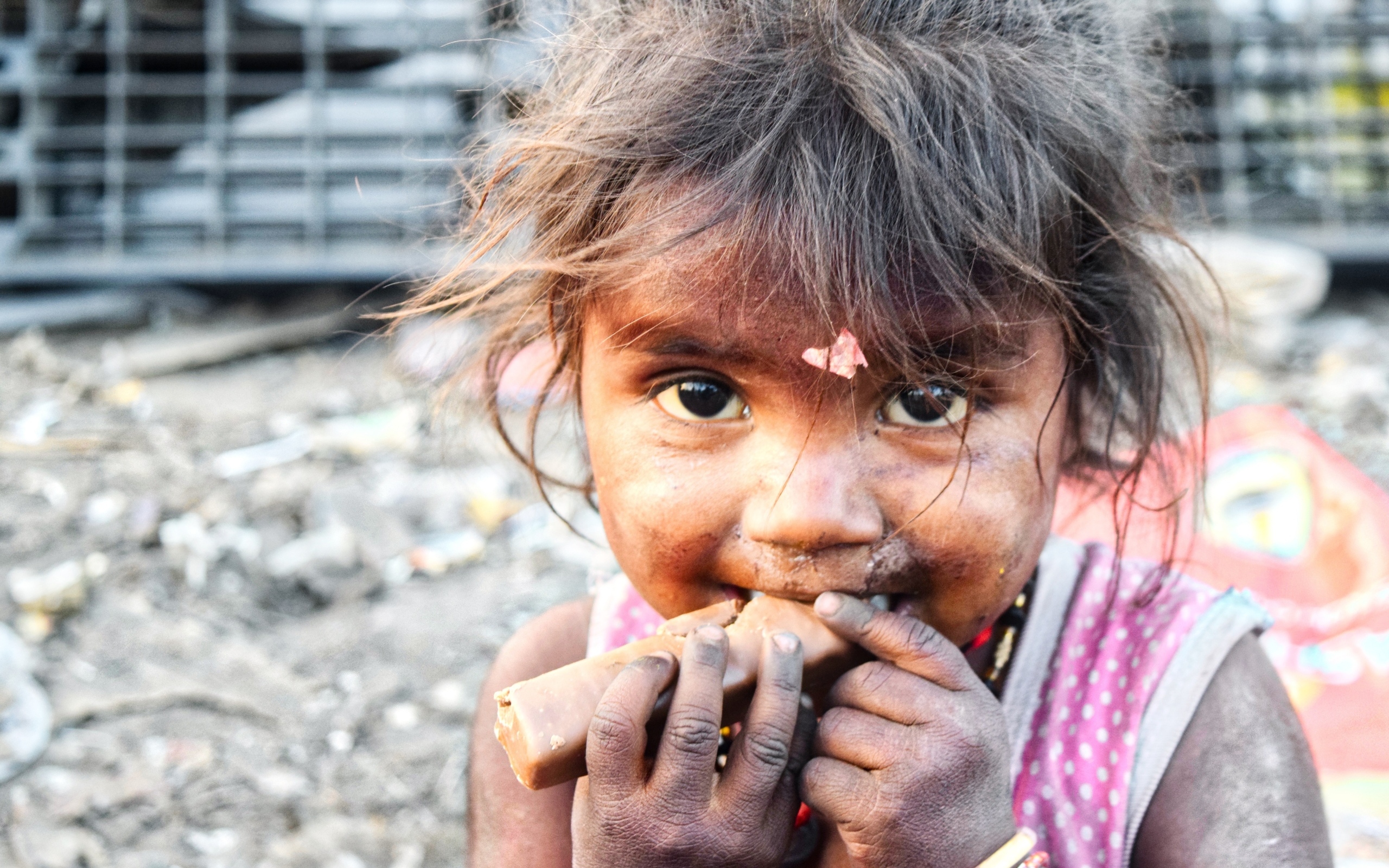 Маленькая азиатская девочка с конфетой в руках