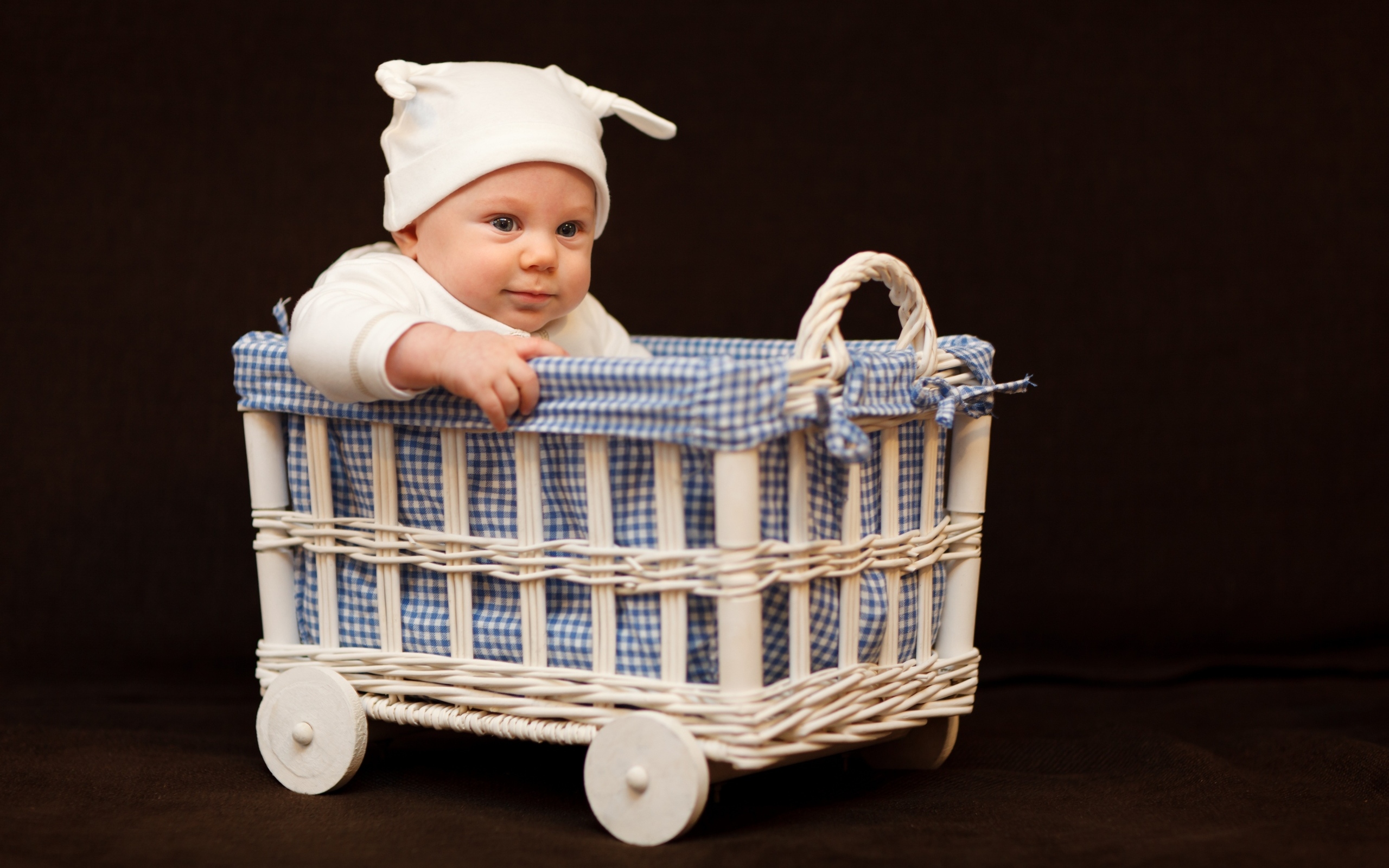 Маленький ребенок в колыбели на коричневом фоне