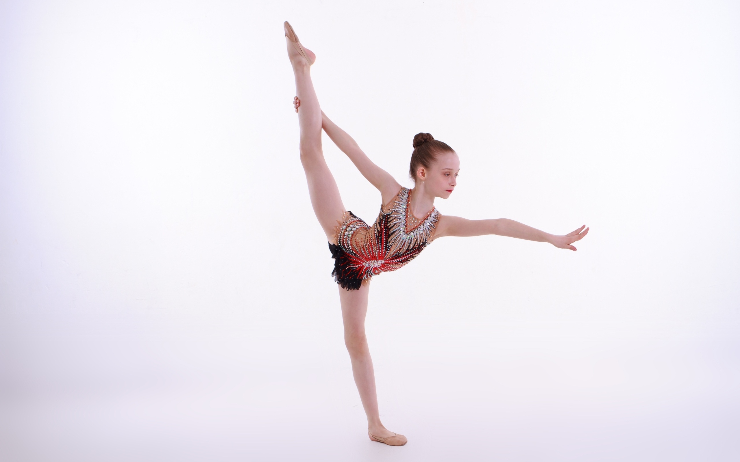 Маленькая девочка гимнастка на белом фоне