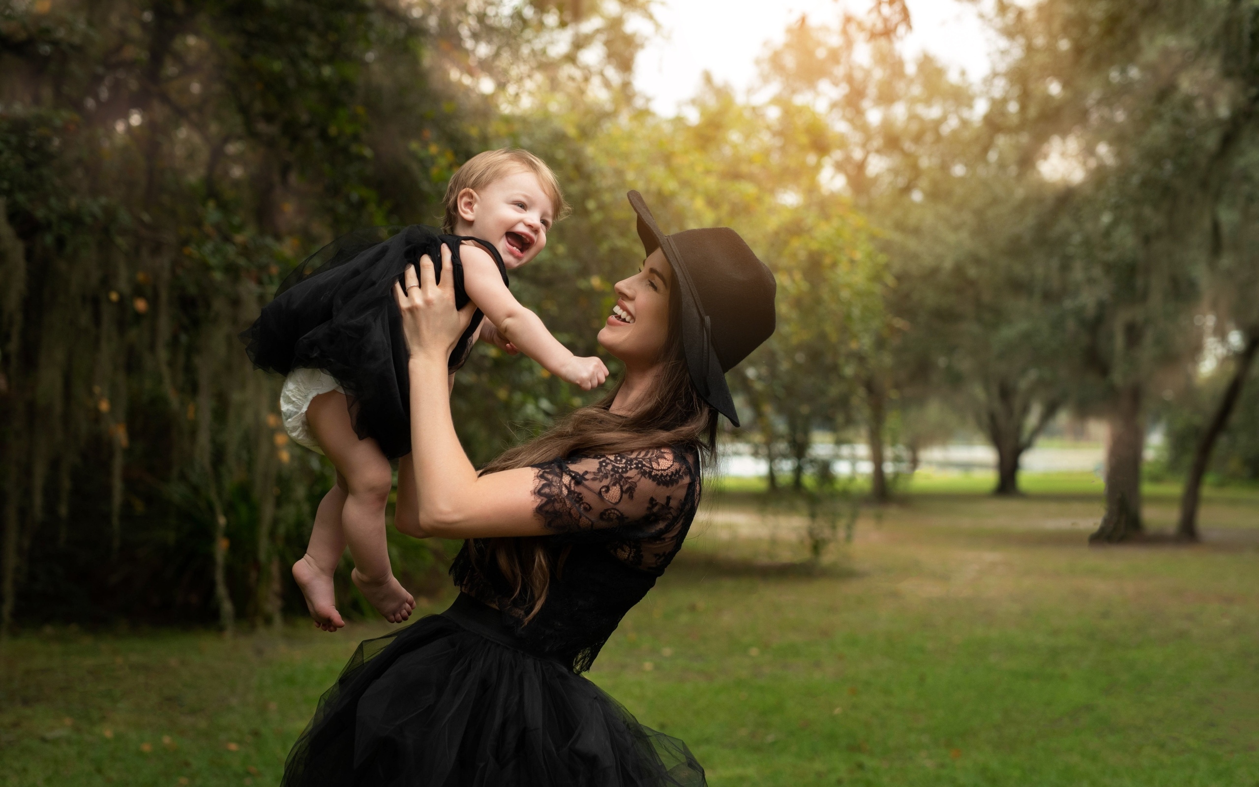 Мама держит улыбающуюся дочь на руках