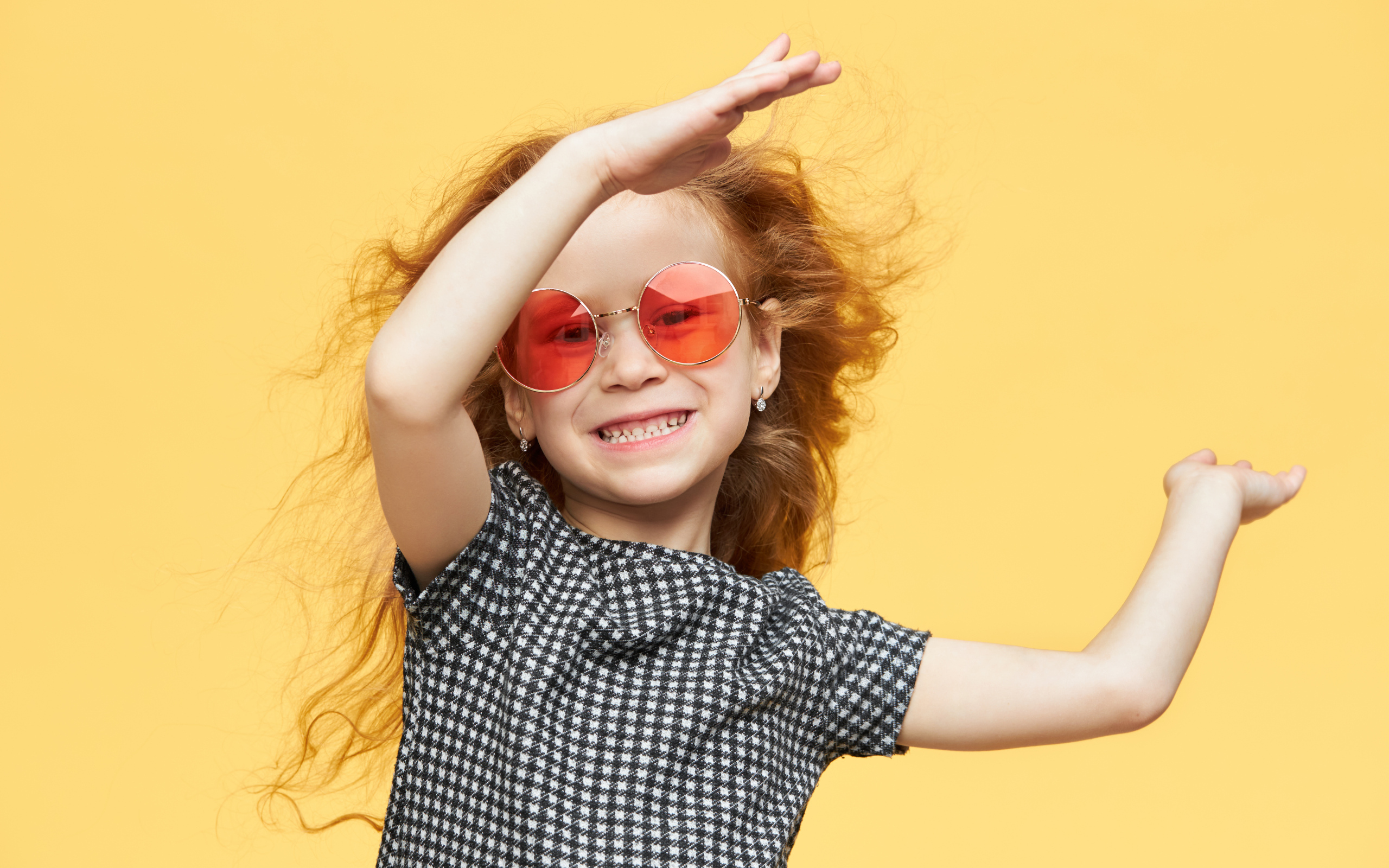 Улыбающаяся рыжеволосая девочка в очках