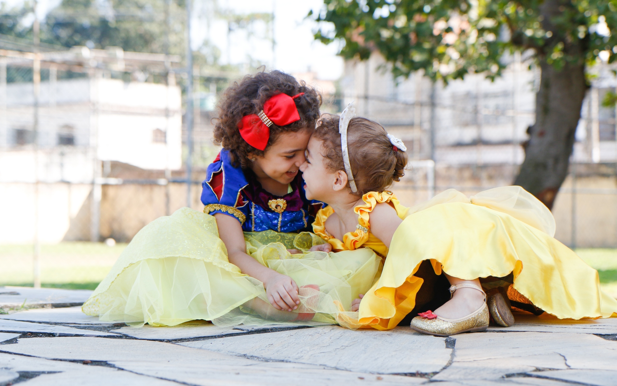 Две маленькие сестры играют под деревом