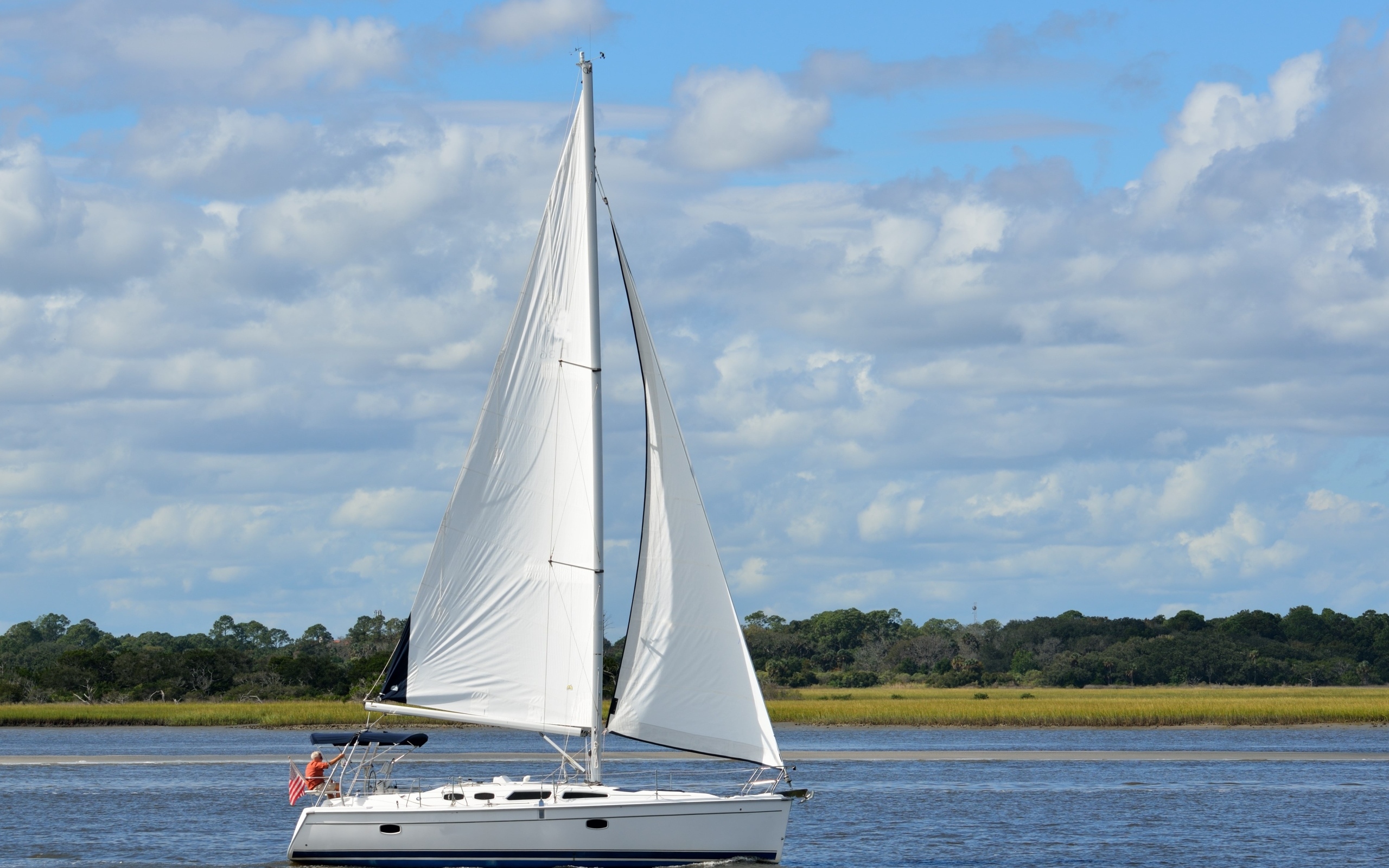 Яхта с белыми парусами на реке