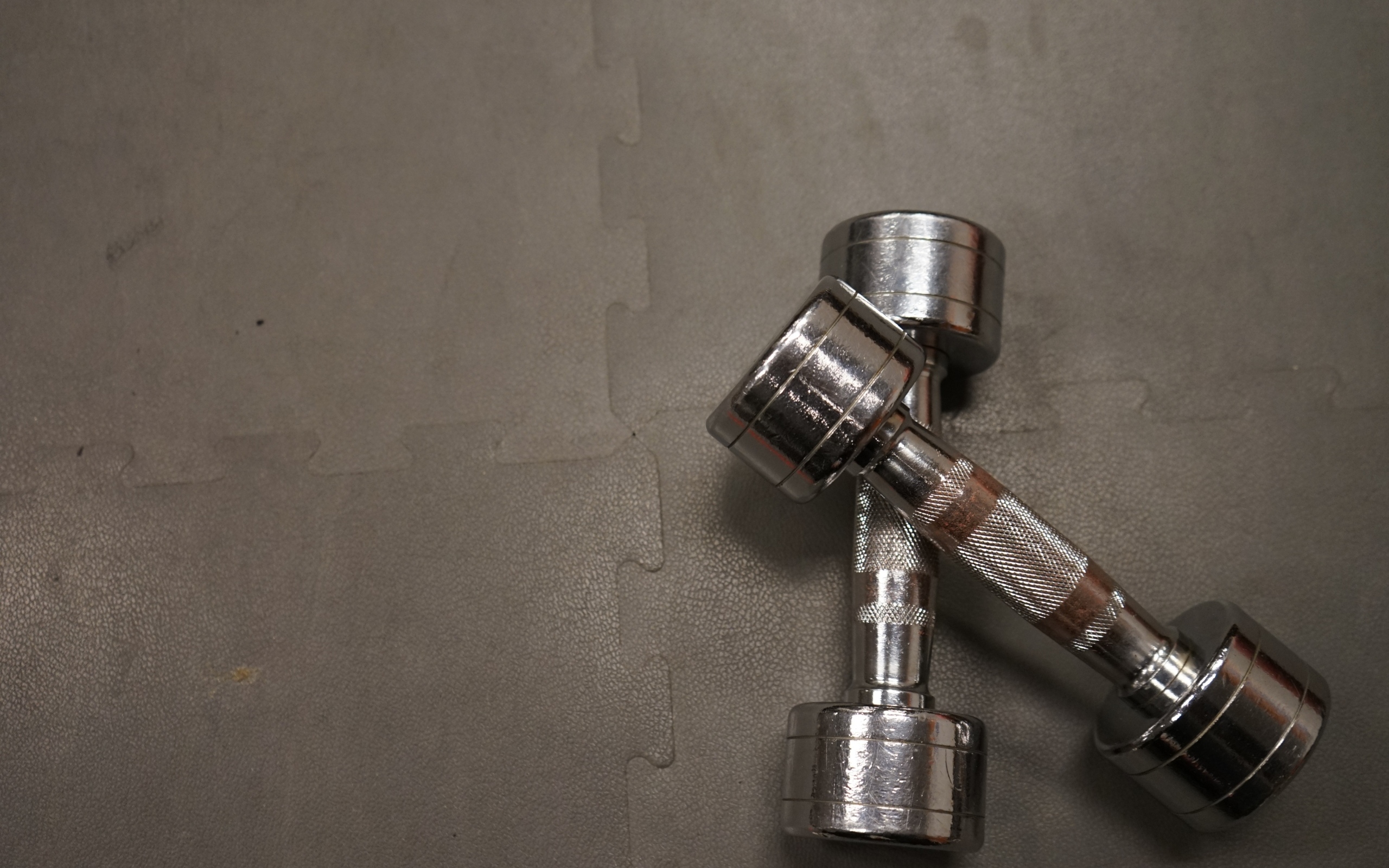 Две железные гантели на сером фоне