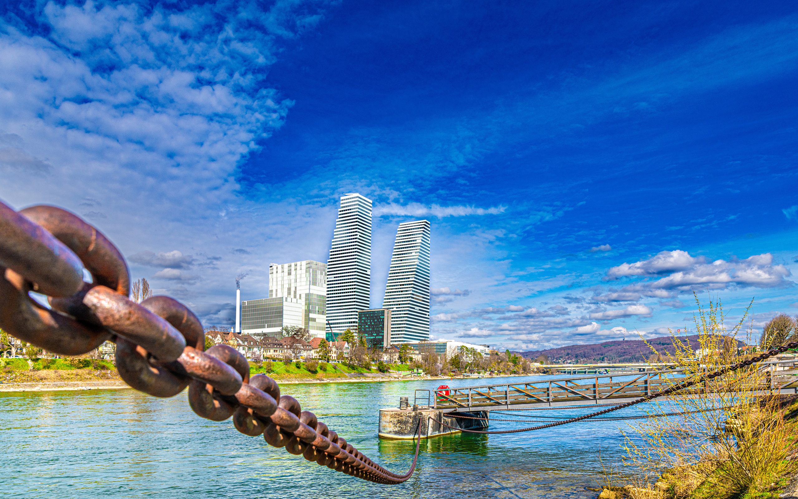 Вид на небоскребы и железные цепи у реки, Швейцария