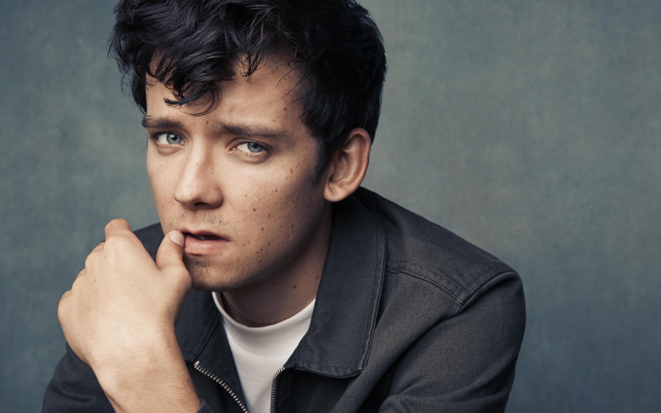 Актер Эйса Баттерфилд на сером фоне