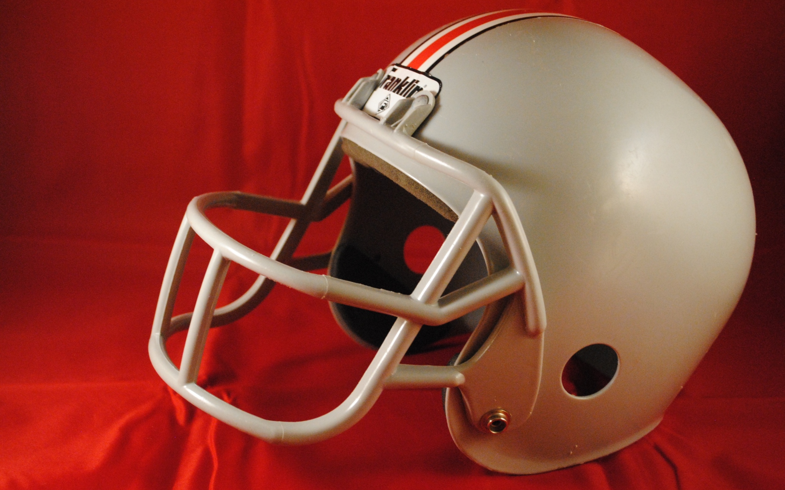 Шлем для игры в американский футбол на красном фоне