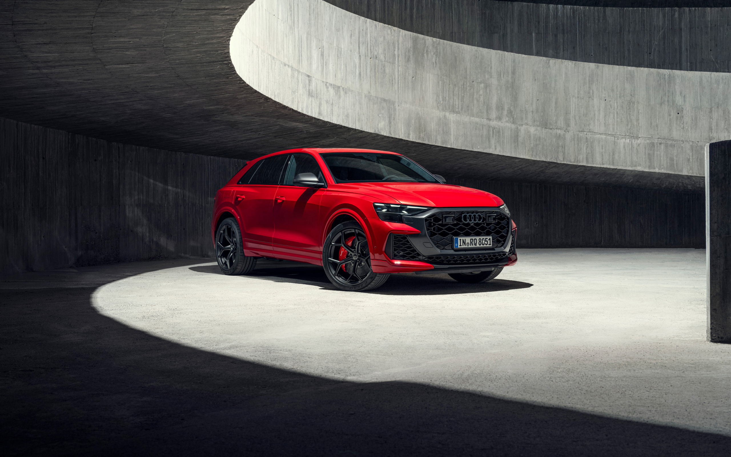 Красный автомобиль Audi RS Q8 performance 2024 года в здании
