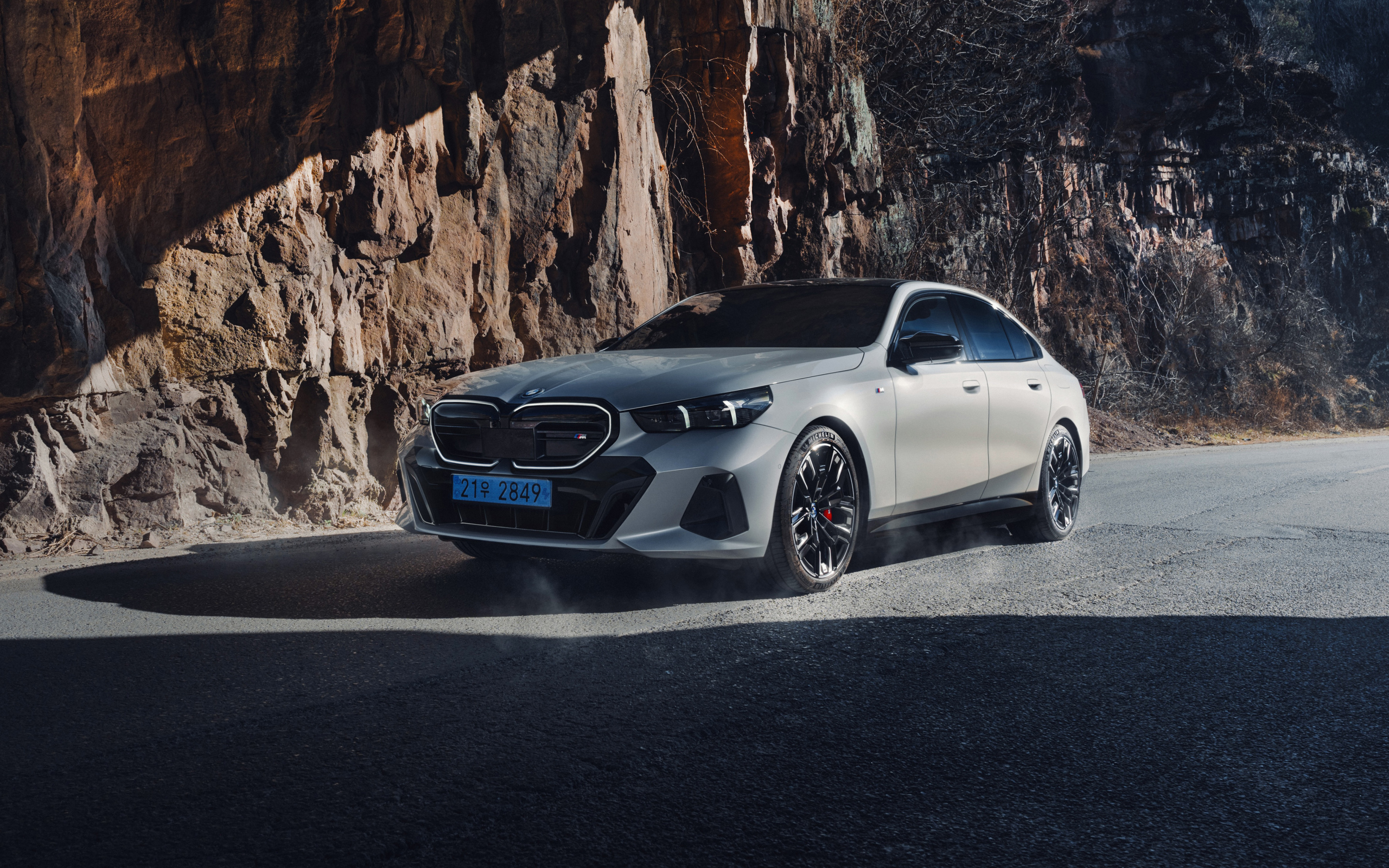 Серебристый автомобиль BMW i5 M60 у горы