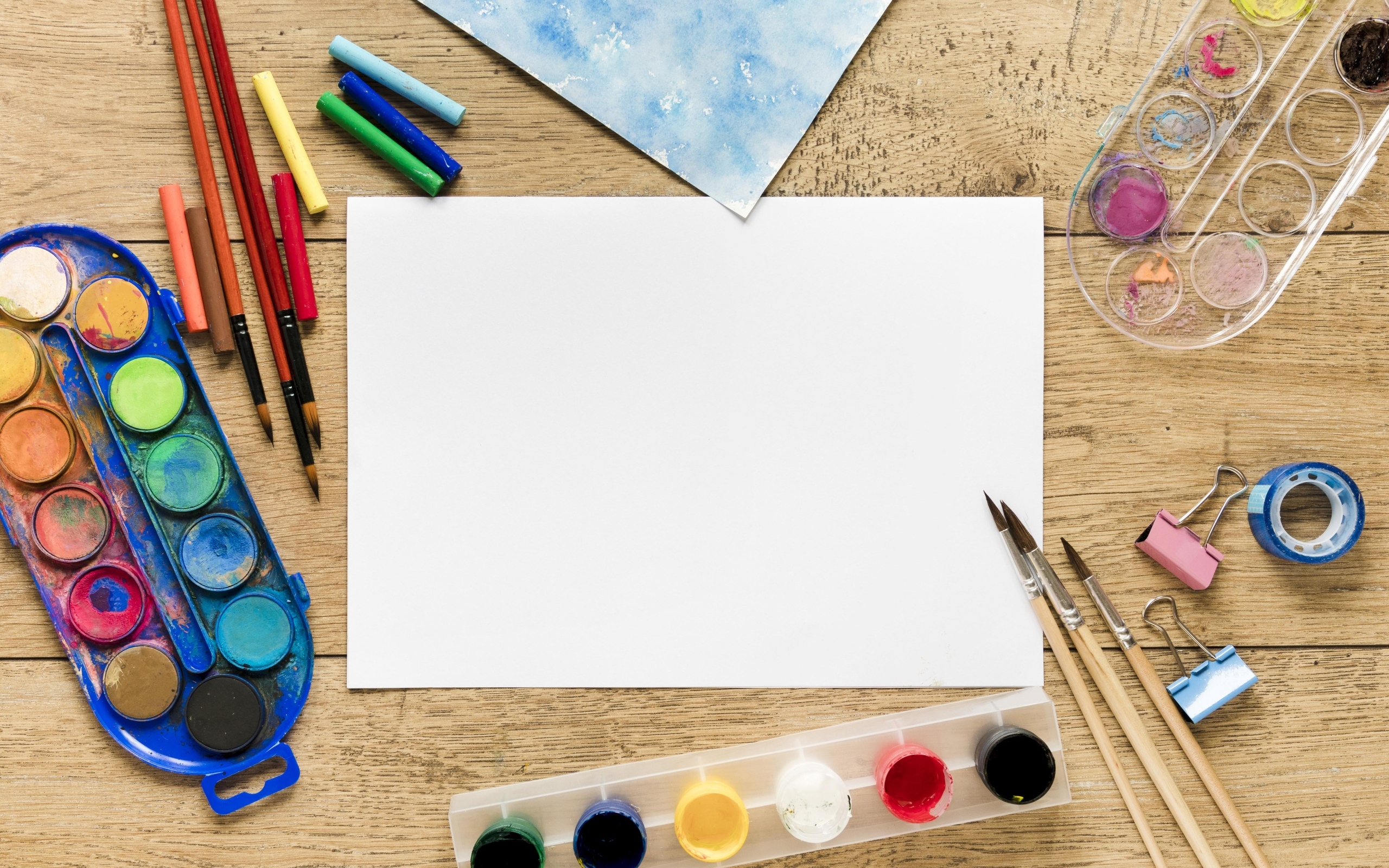 Предметы для рисования с листом бумаги на столе