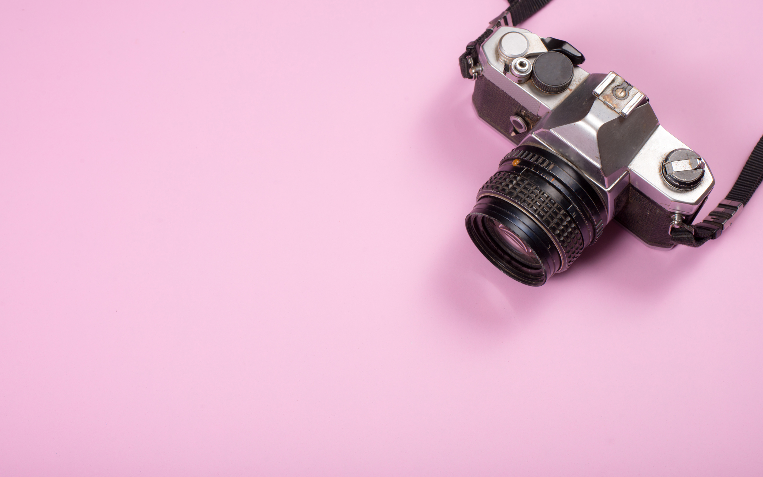 Старый фотоаппарат на розовом фоне