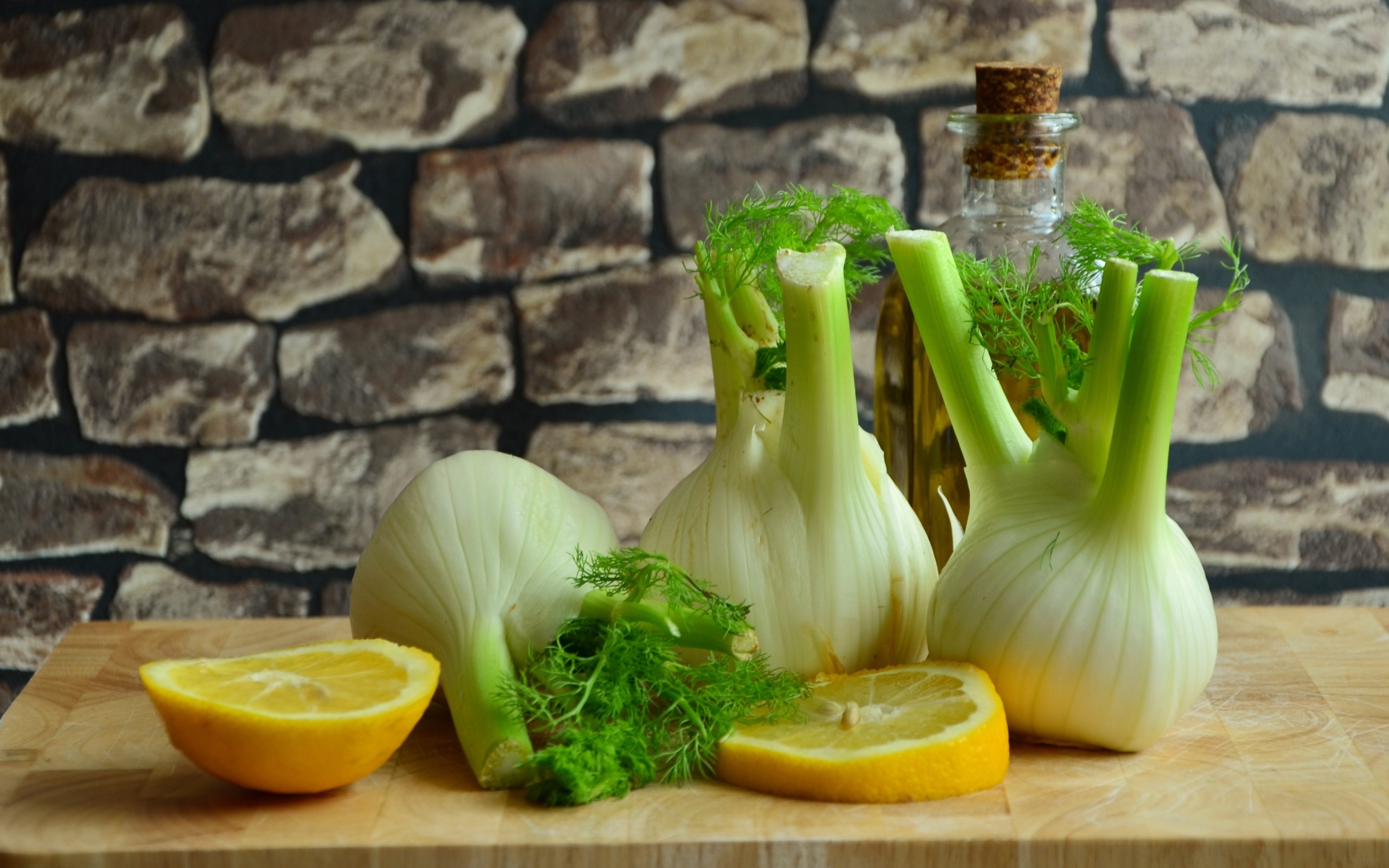 Луковицы фенхеля с кусочками лимона и маслом на столе