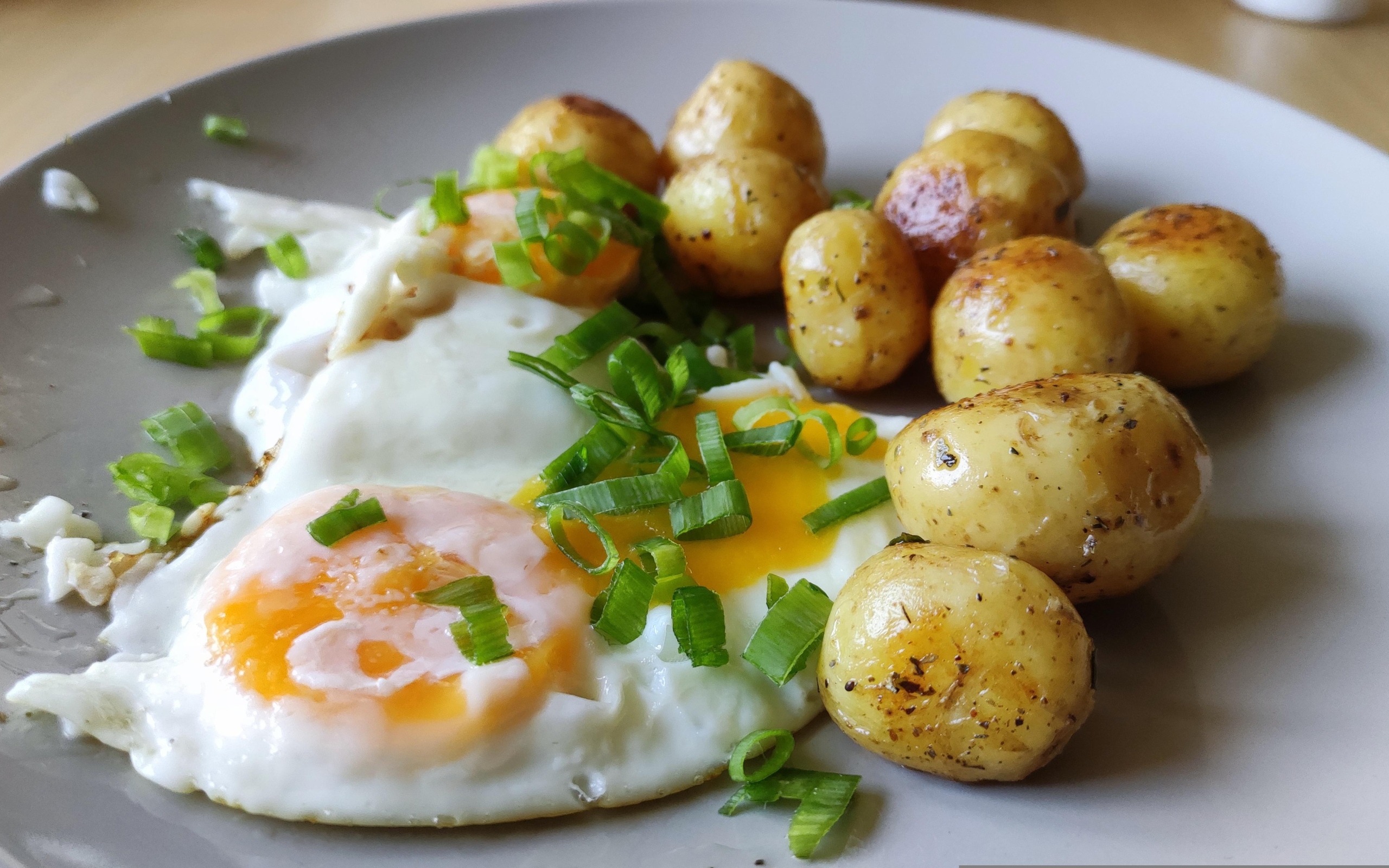Молодая жареная картошка с яичницей и зеленым луком