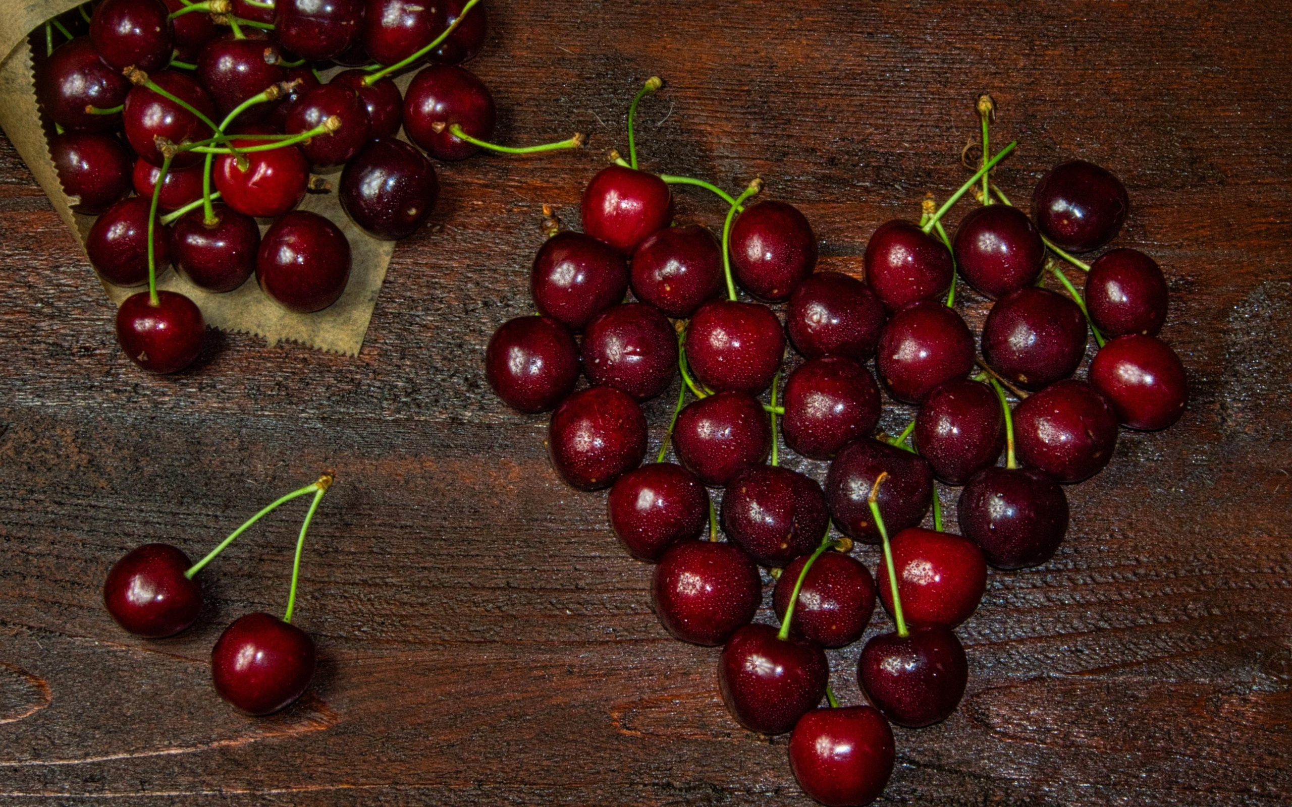 Сердце из спелых ягод черешни на деревянном столе