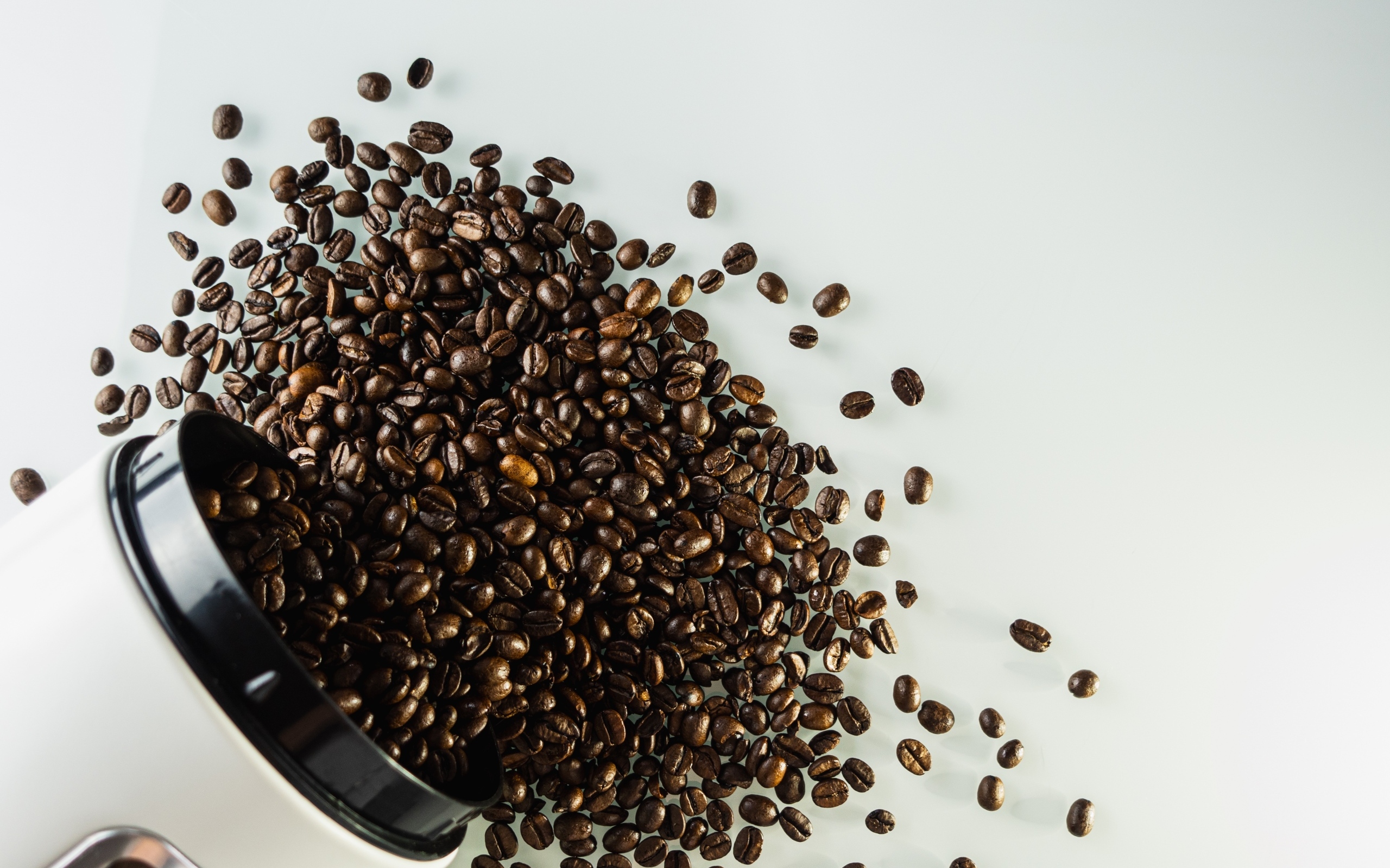 Много кофейных зерен на сером столе