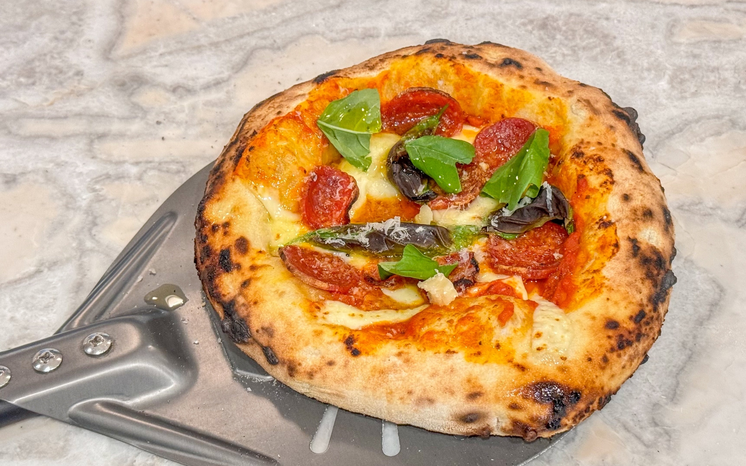 Маленькая пицца на лопате на столе