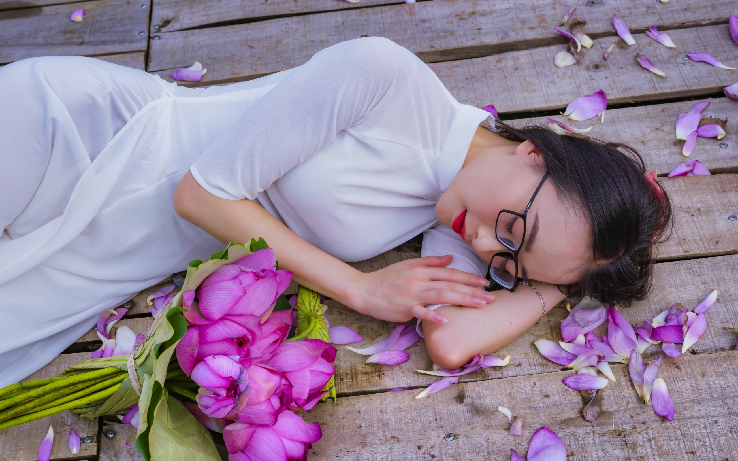 Девушка азиатка лежит с цветами лотоса