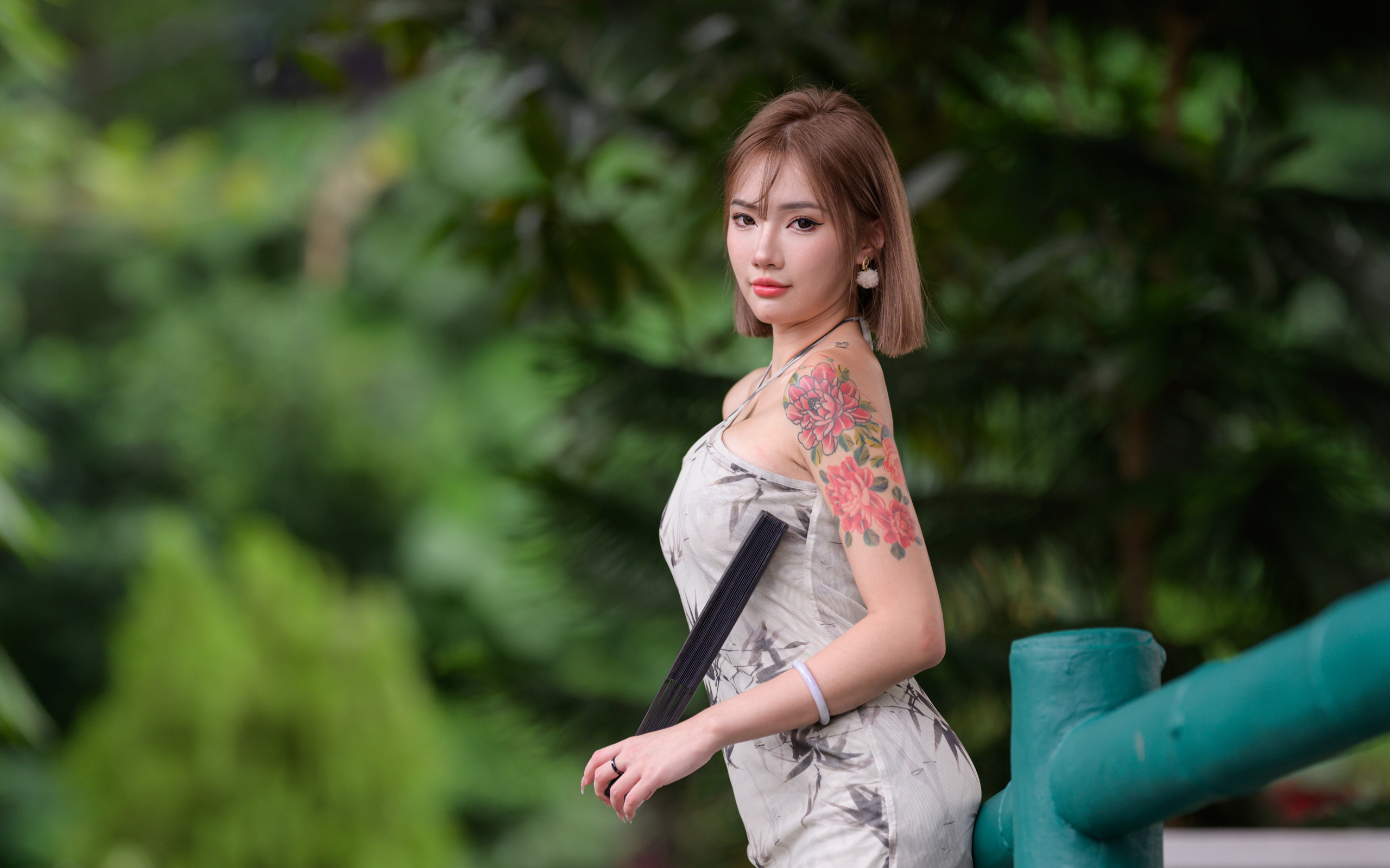 Красивая девушка азиатка с татуировкой на руке