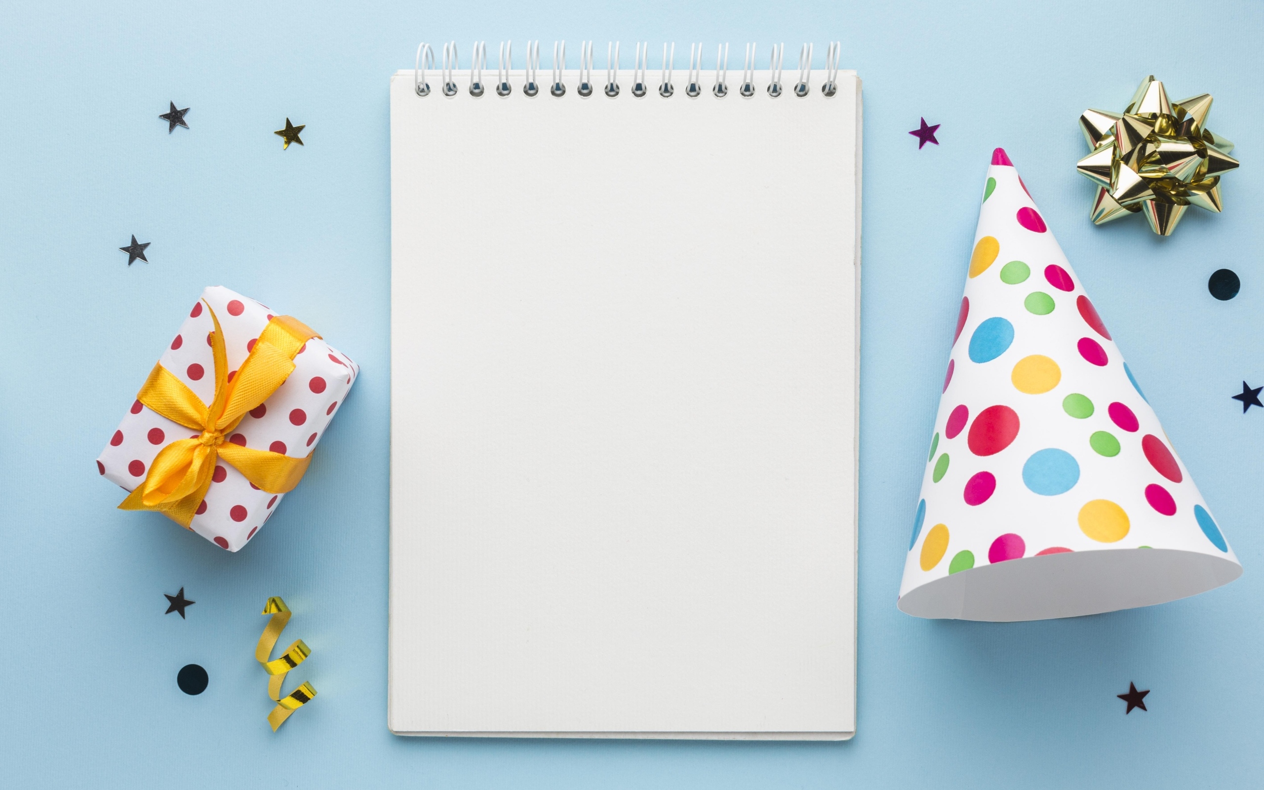 Подарок и колпак с блокнотом на голубом фоне, шаблон открытки