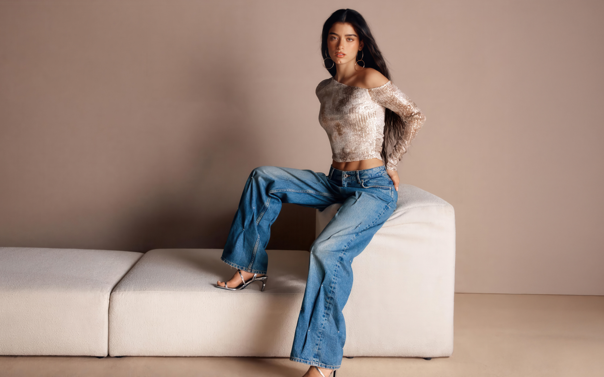 Знаменитая певица Дикси Дамелио в джинсах у дивана