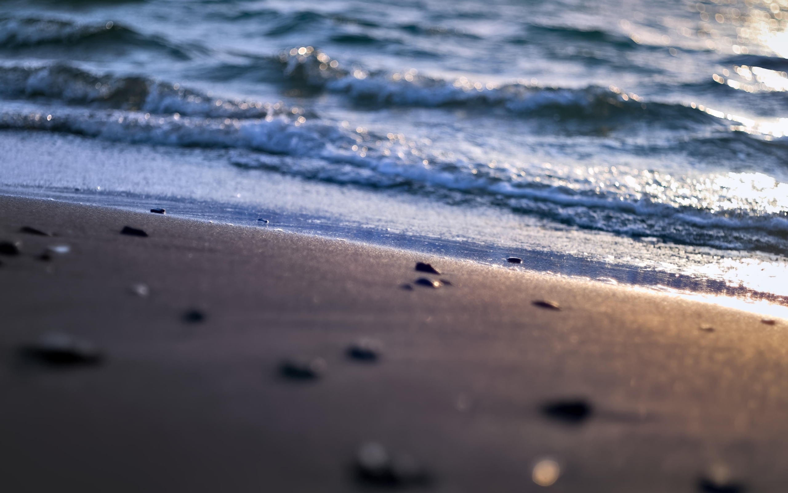 Мокрый морской песок омывает вода