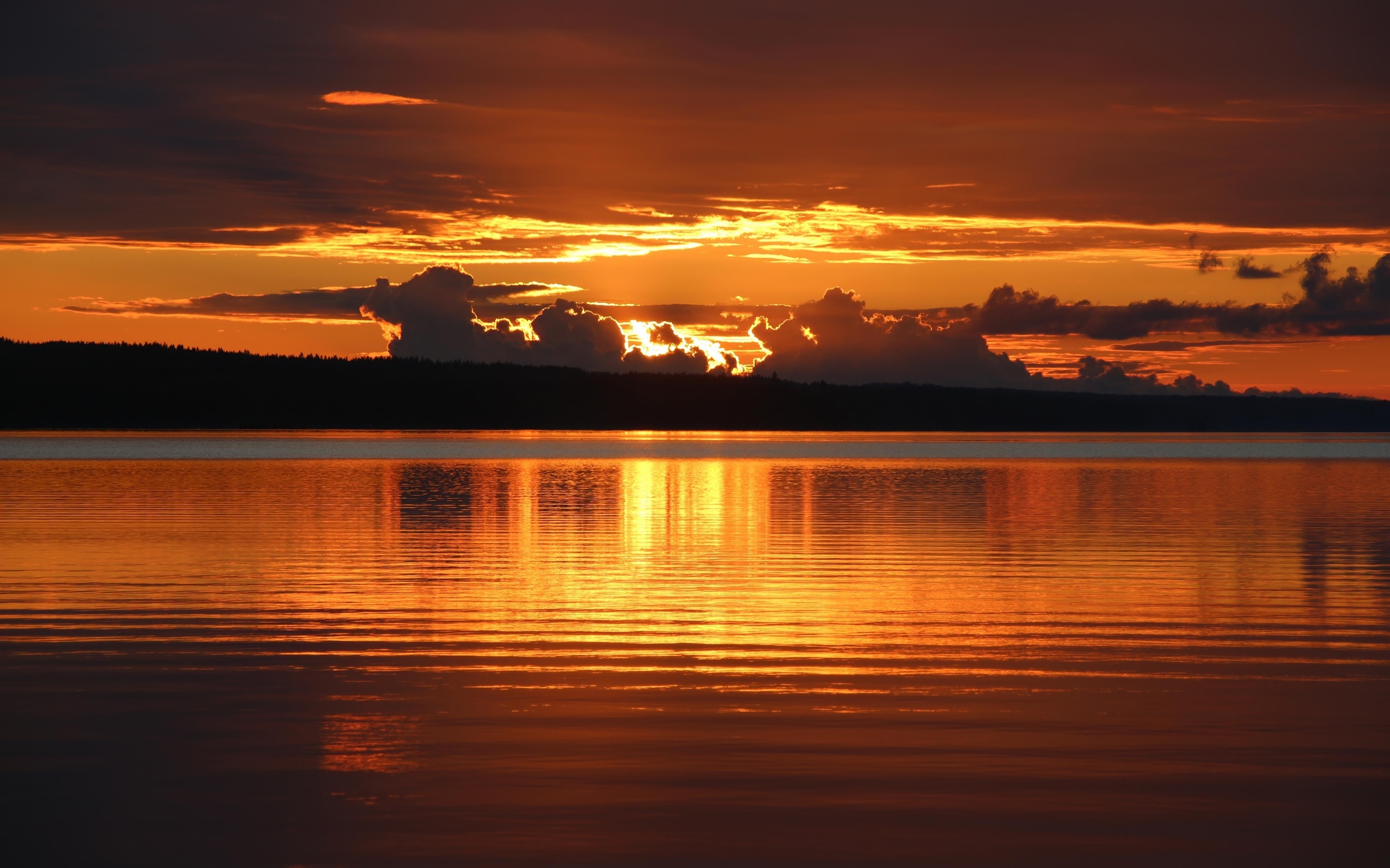 Красивый закат в облаках на горизонте у озера