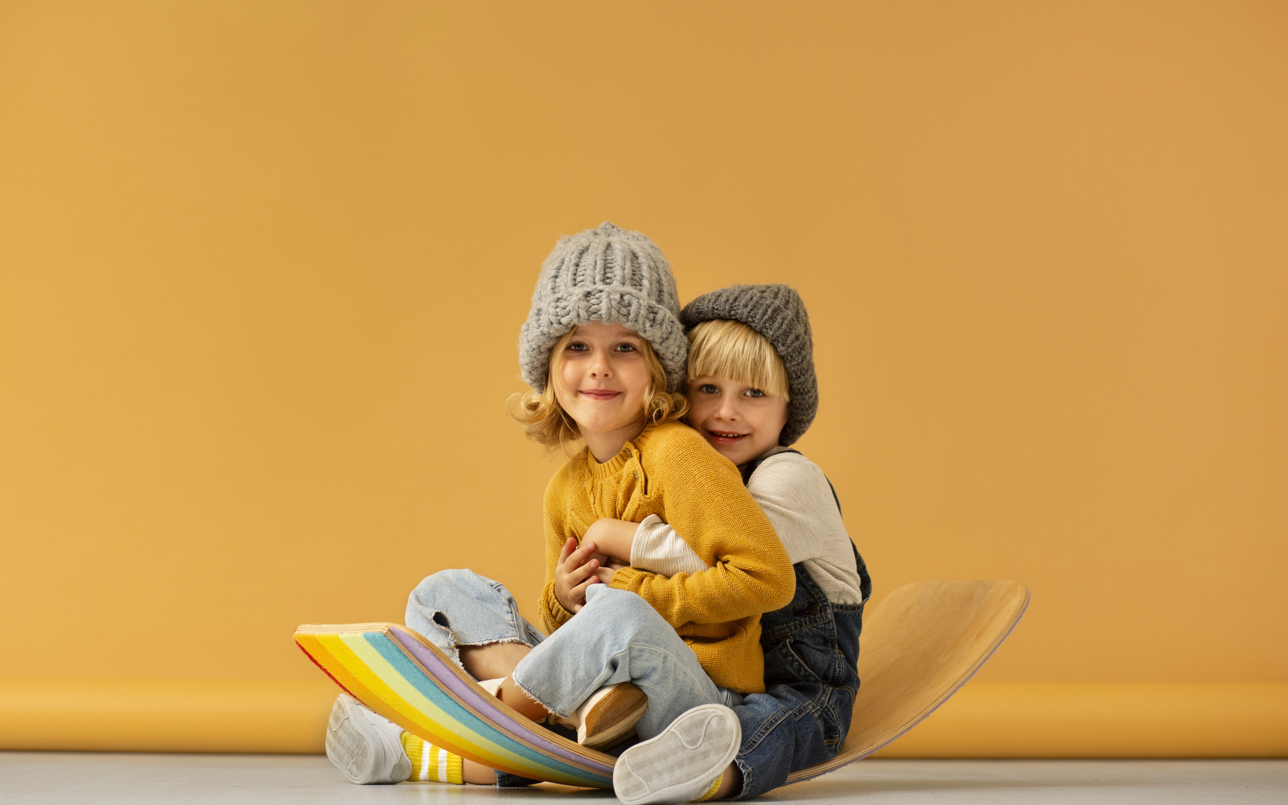 Счастливые брат и сестра в теплых шапках