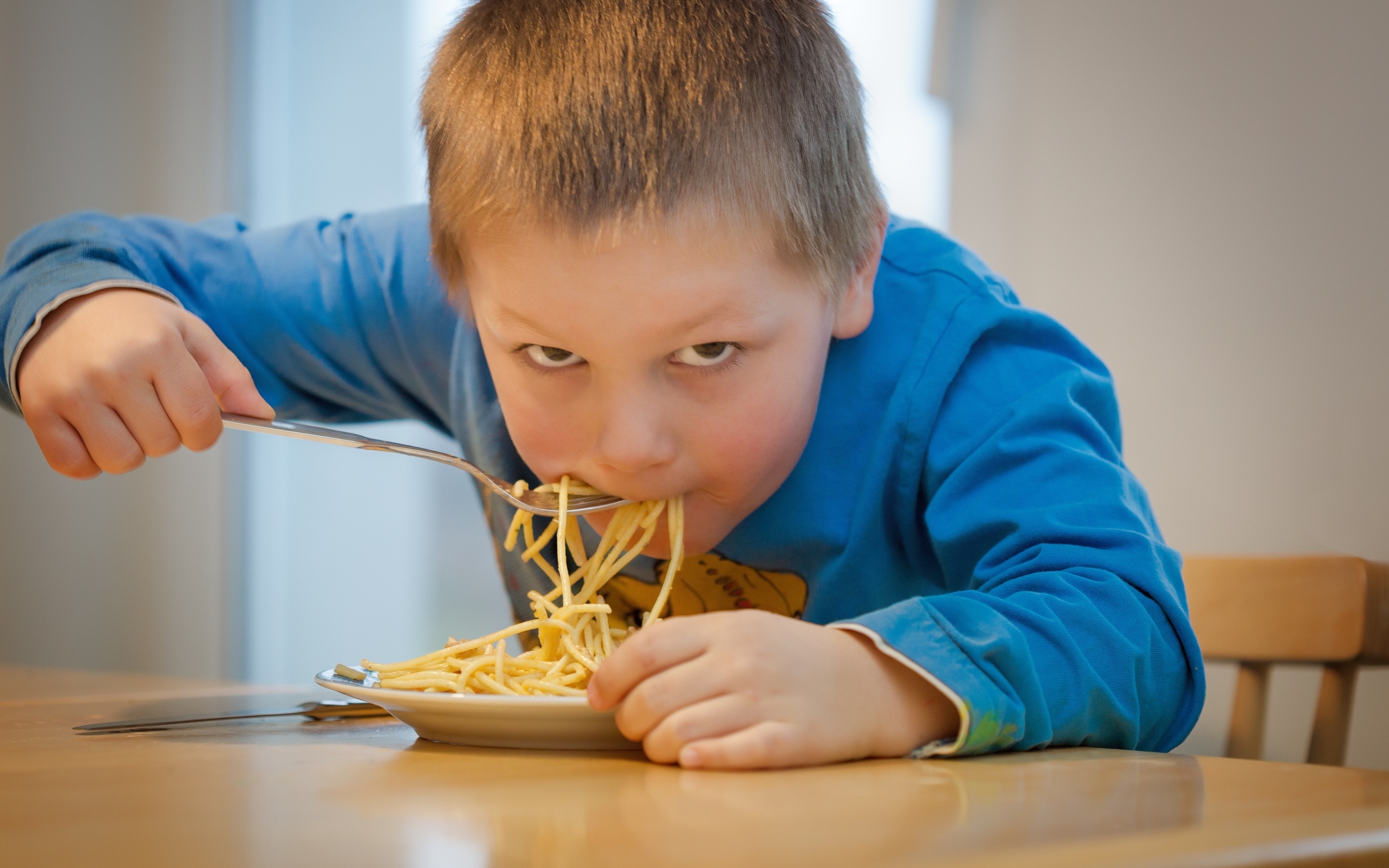 Маленький мальчик ест макароны