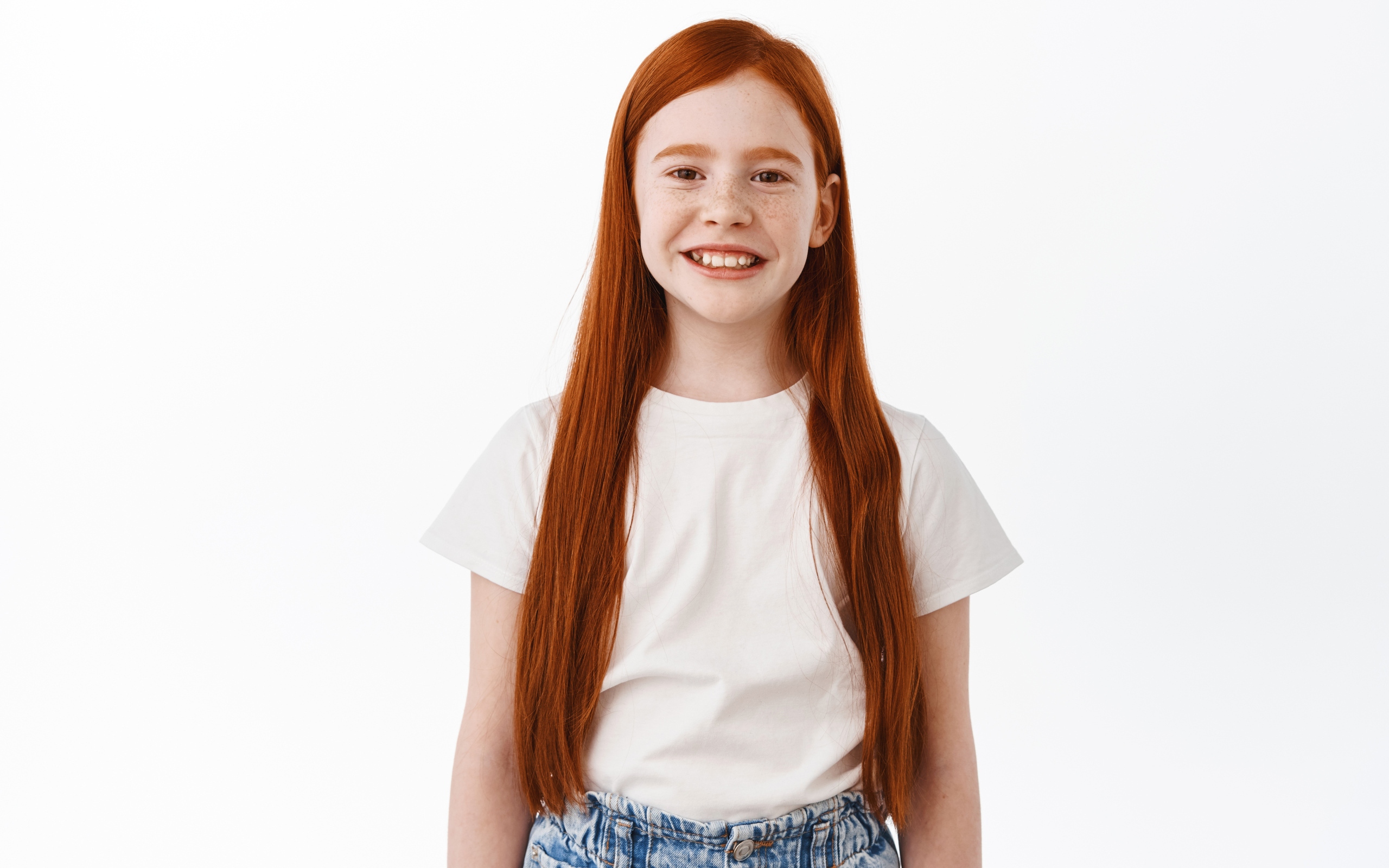 Улыбающаяся рыжеволосая девочка на белом фоне