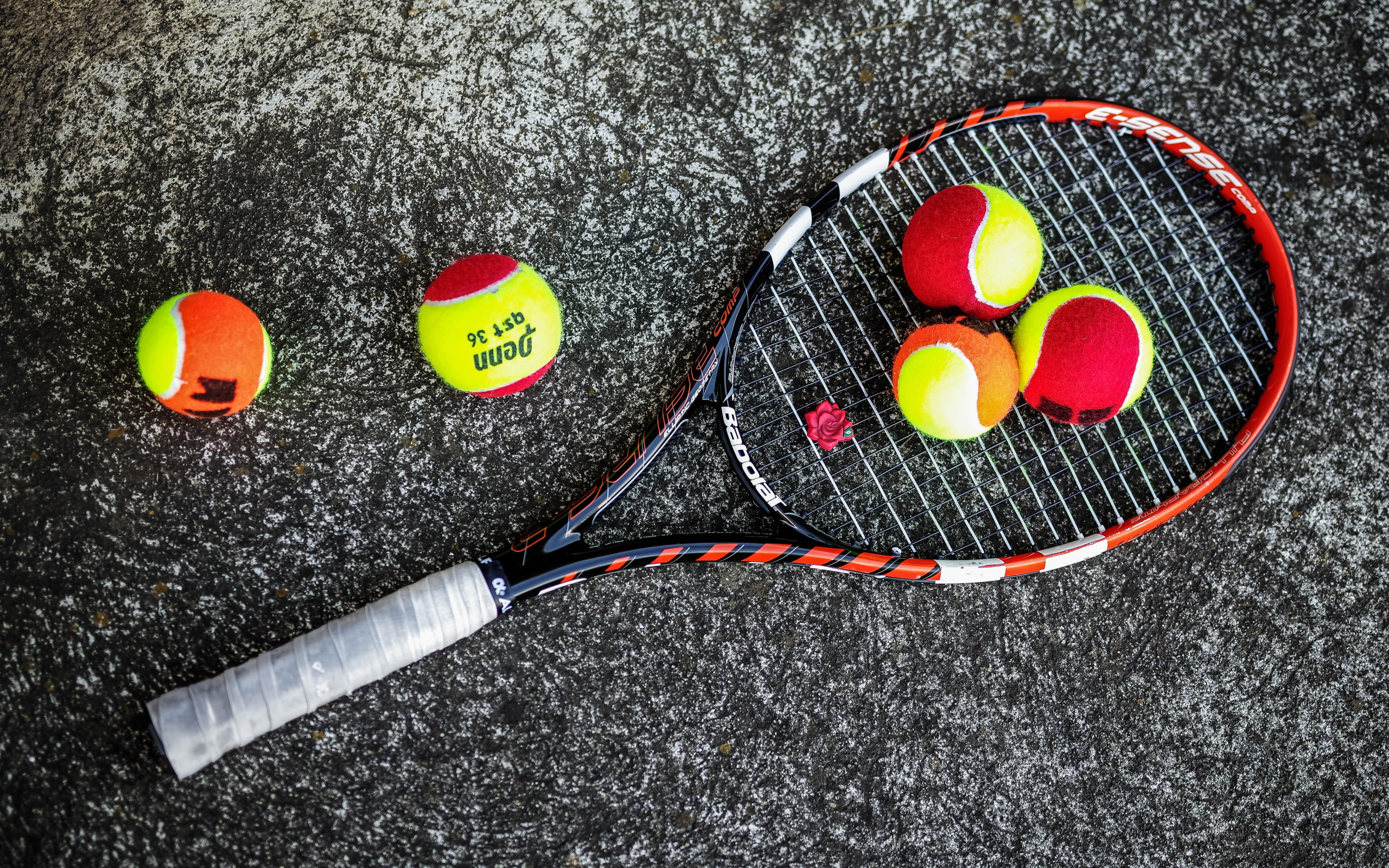 Ракетка и теннисные мячи на черном фоне