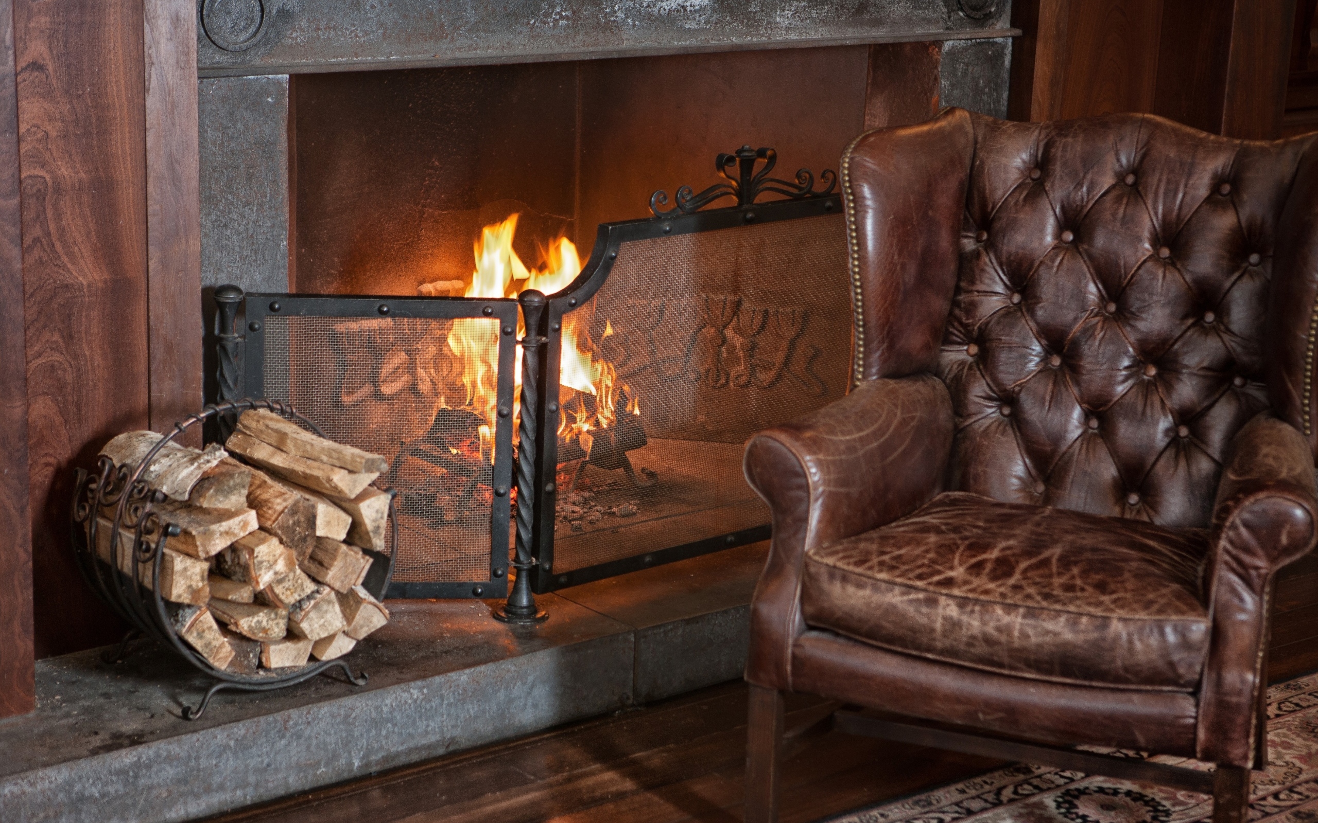 Кожаное кресло стоит у зажженного камина