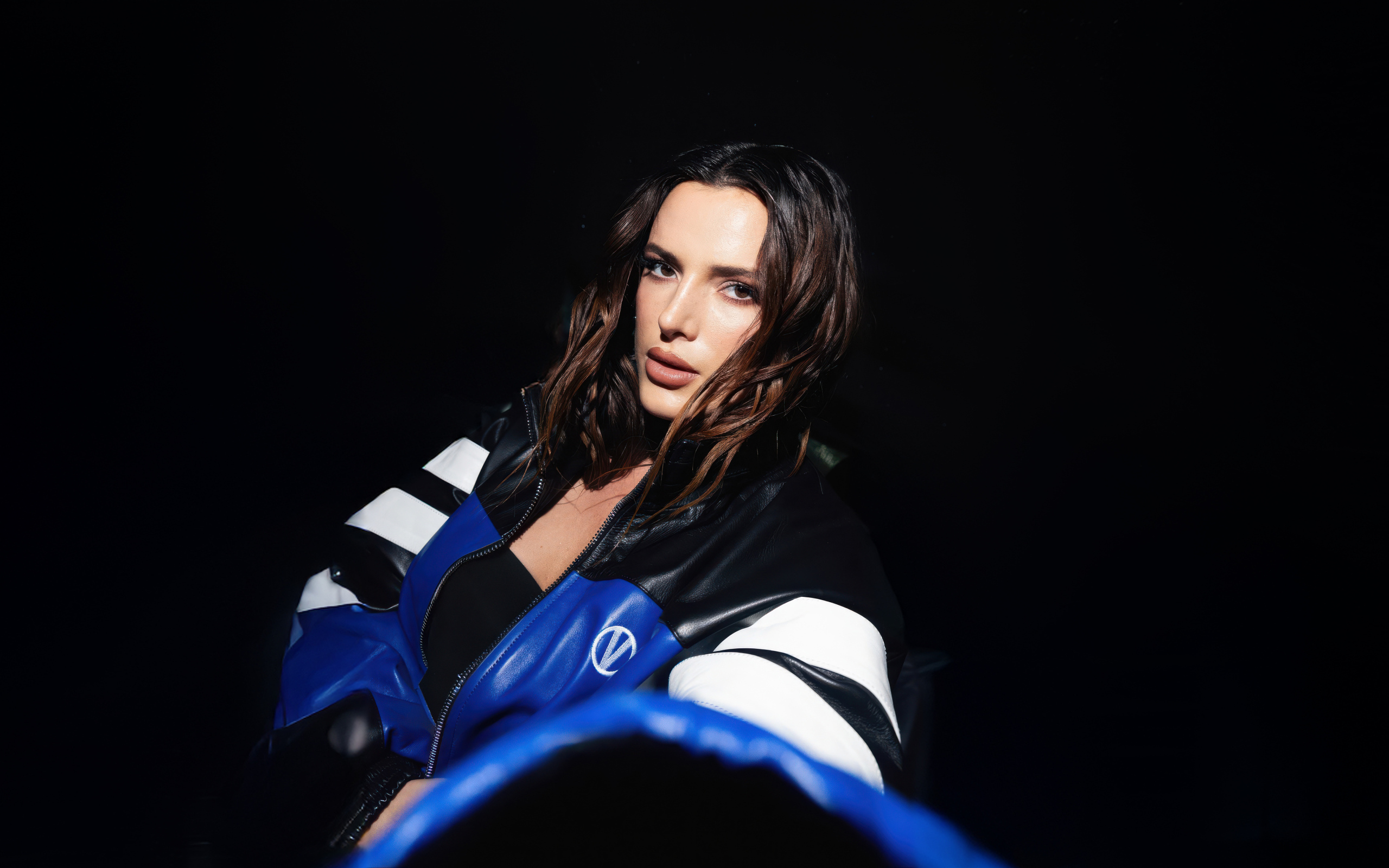 Актриса Белла Торн в кожаной куртке на черном фоне