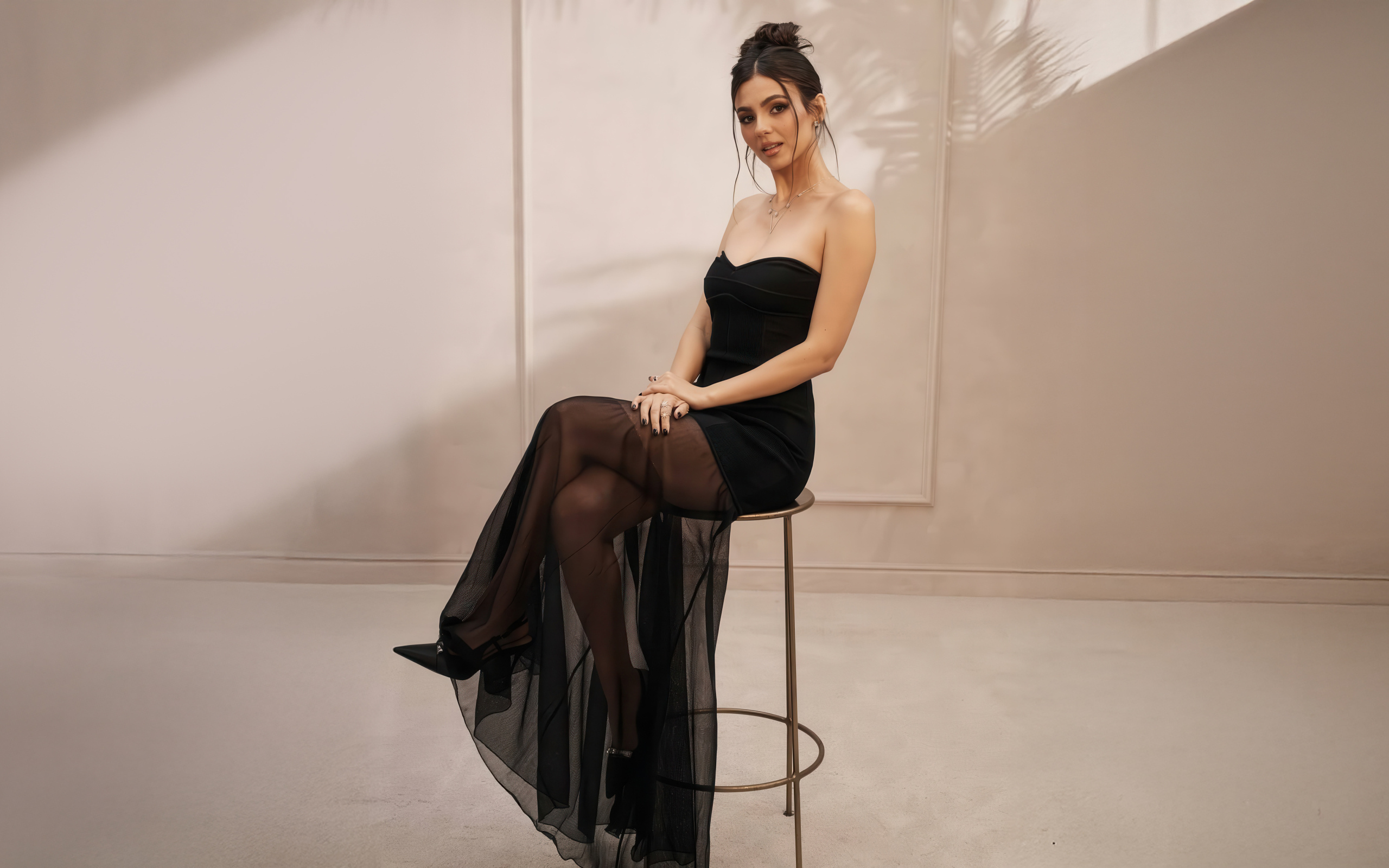 Американская актриса Виктория Джастис в черном платье на стуле