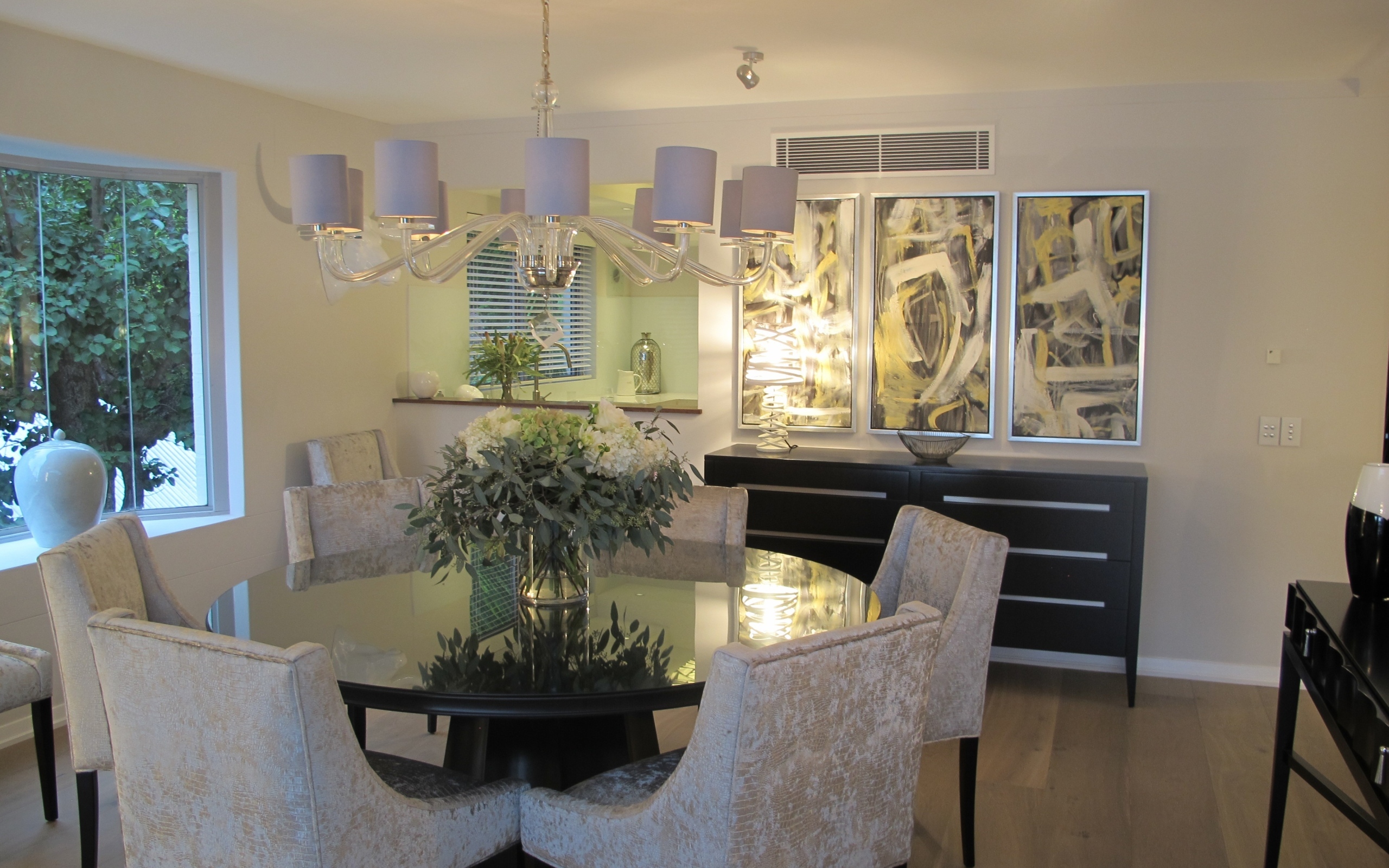 Большой стол со стульями в столовой с большой люстрой