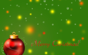 Красный ёлочный шар на зелёном фоне на рождество