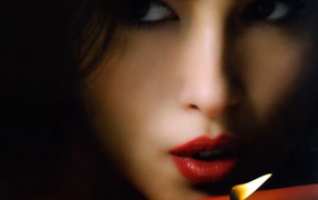 Брюнетка задувает свечу