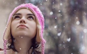 Девушка смотрит на падающий снег