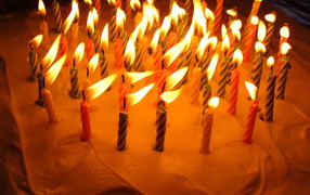 Colored candles and cream birthday cake