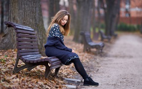 Cute girl sitting in autumn park