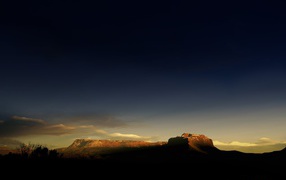 Солнце на закате освещает гору