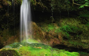 Струи воды на зеленые камни