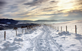 Заснеженная дорога под красивыми облаками