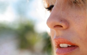 Blonde girl with piercing in a nose close-up
