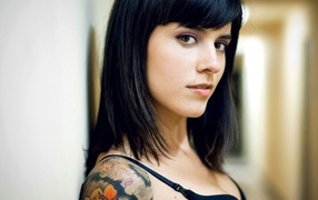 Brunette girl with pierced lip and a tattoo on her shoulder