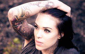 Brunette girl with piercing in nose and a tattoo on her arm