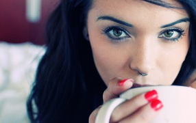 Brunette girl with piercing in nose and red nails