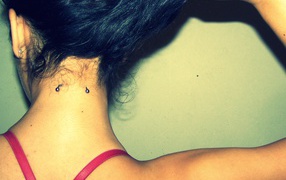 Девушка брюнетка с пирсингом в шее