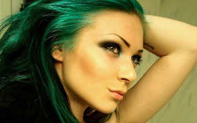 Green-haired girl with a pierced nose and tattoos on arm