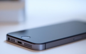 New Iphone 5S space gray color is on a white table